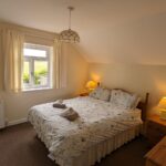 Double bedroom in a Brooklands cottage apartment with a countryside view from the window