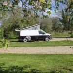 Motorhome on a level pitch at Brooklands with open countryside behind